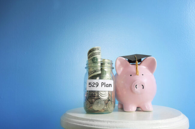 Piggy,Bank,With,Graduation,Cap,And,529,Plan,Coin,Jar