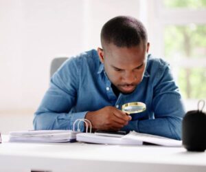 man looking at the fine print with a magnifying glass