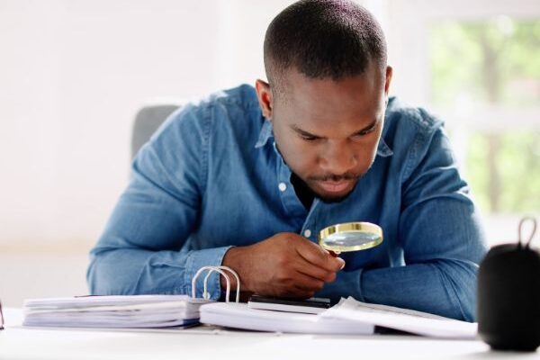 man looking at the fine print with a magnifying glass