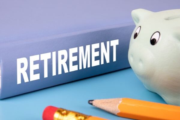 piggy bank, pencils, and a retirement book
