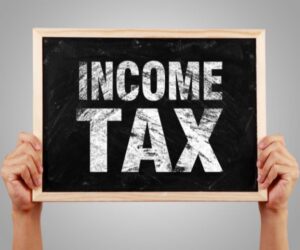 person holding up sign that says income tax