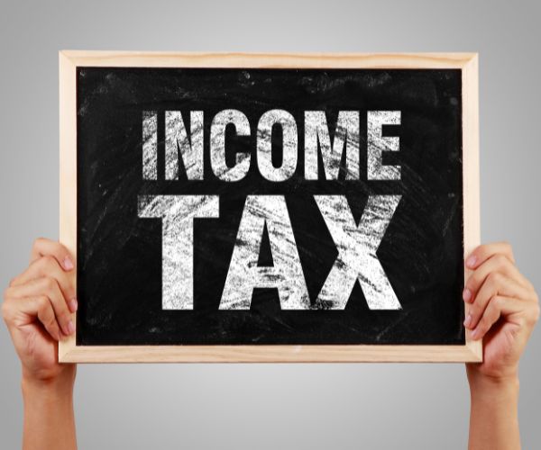 person holding up sign that says income tax